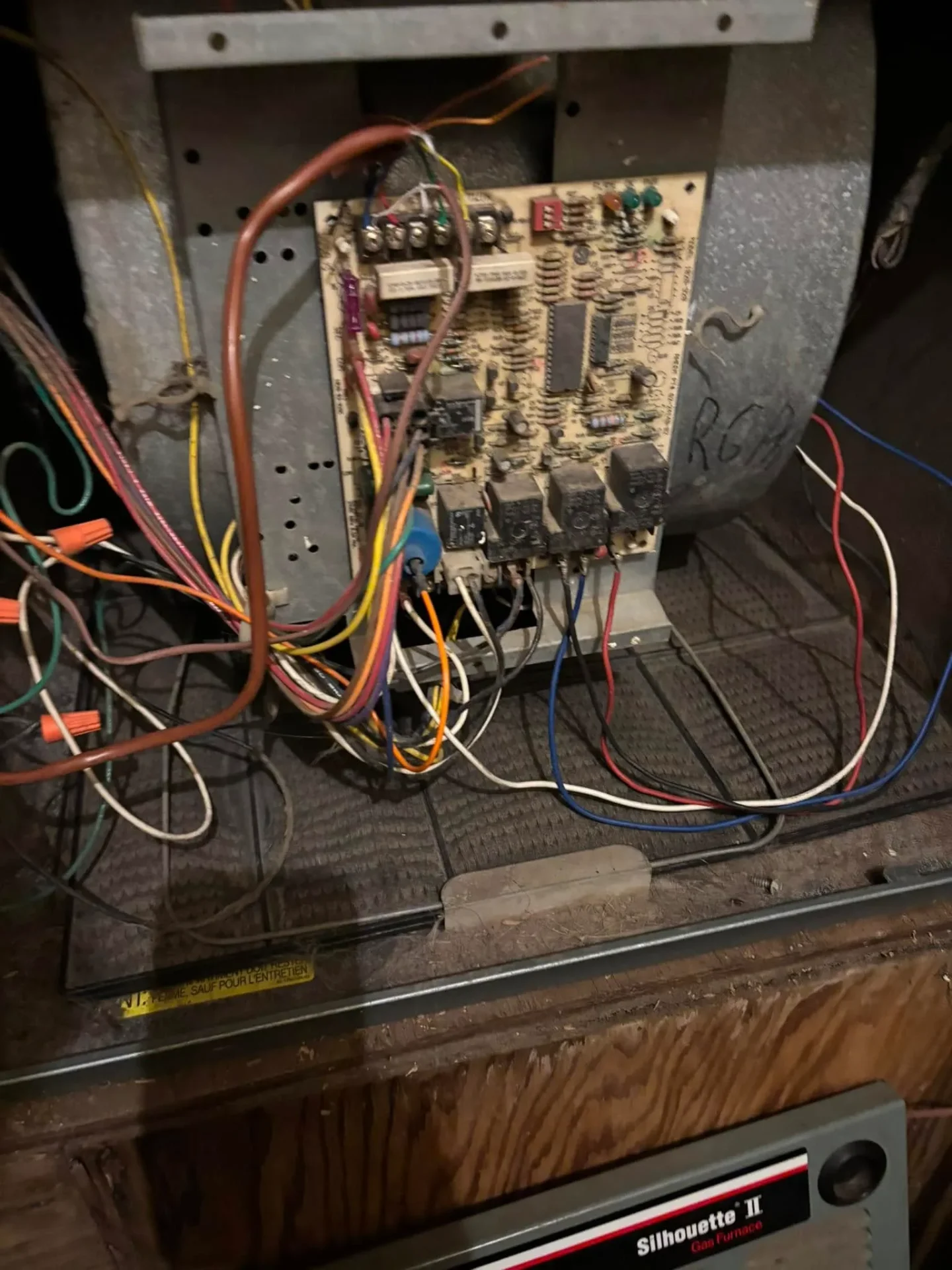 Furnace circuit board wiring inspected during heating service